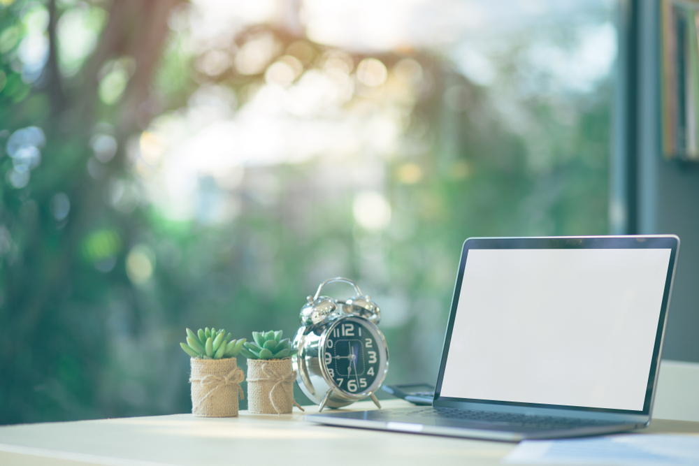 comfortable,workspace,,office,desk,with,blank,screen,laptop,and,clock,